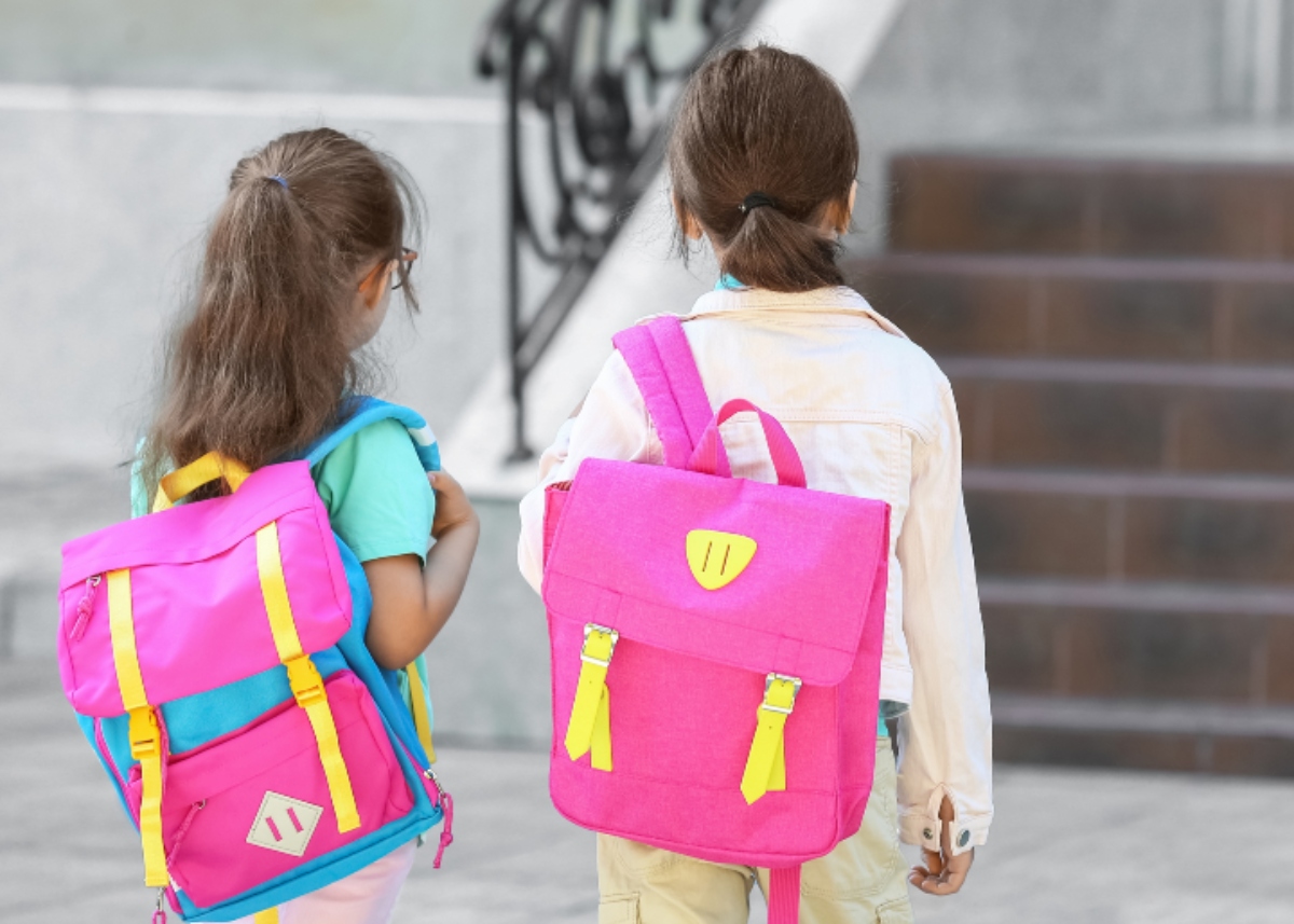 regreso a clases sostenible, mochilas, dos niñas con mochilas llegando a la escuela, Nueva Onda
